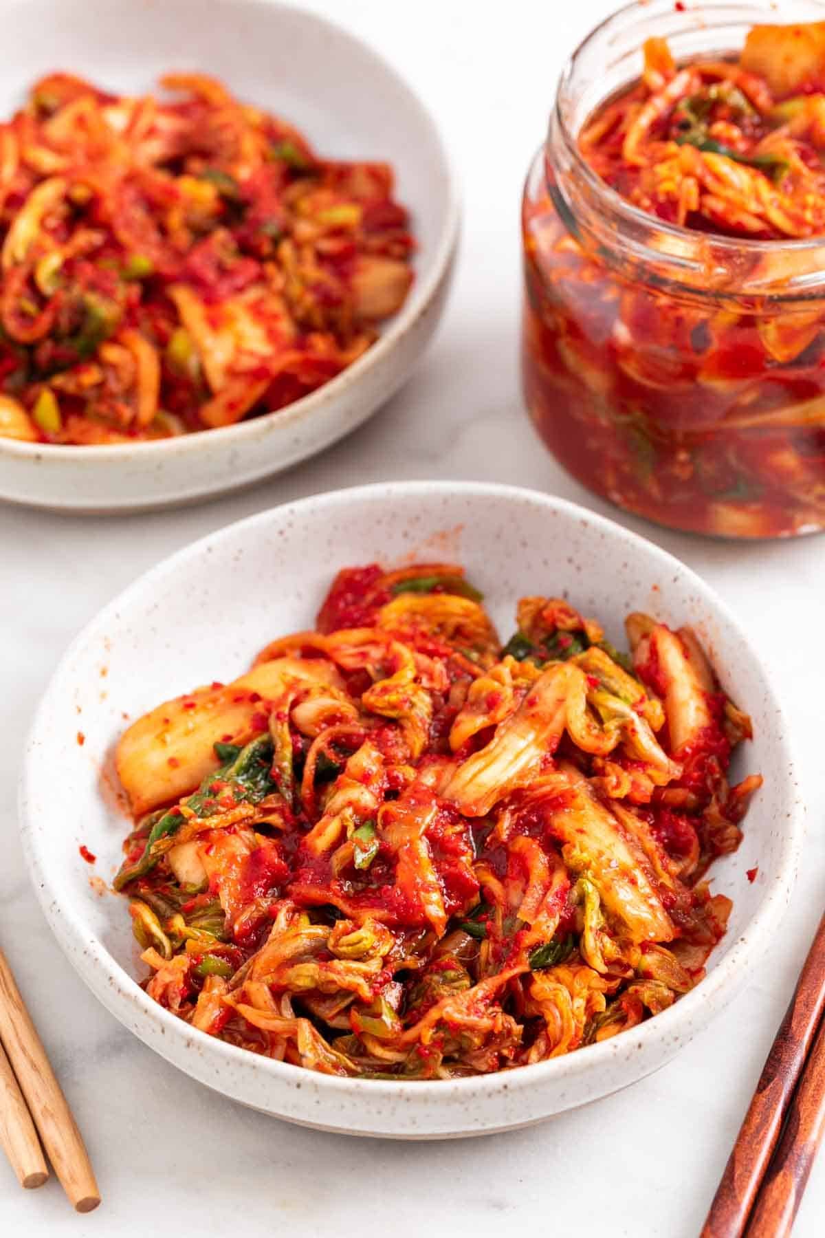 Kimchi casero en dos platos y un tarro de cristal
