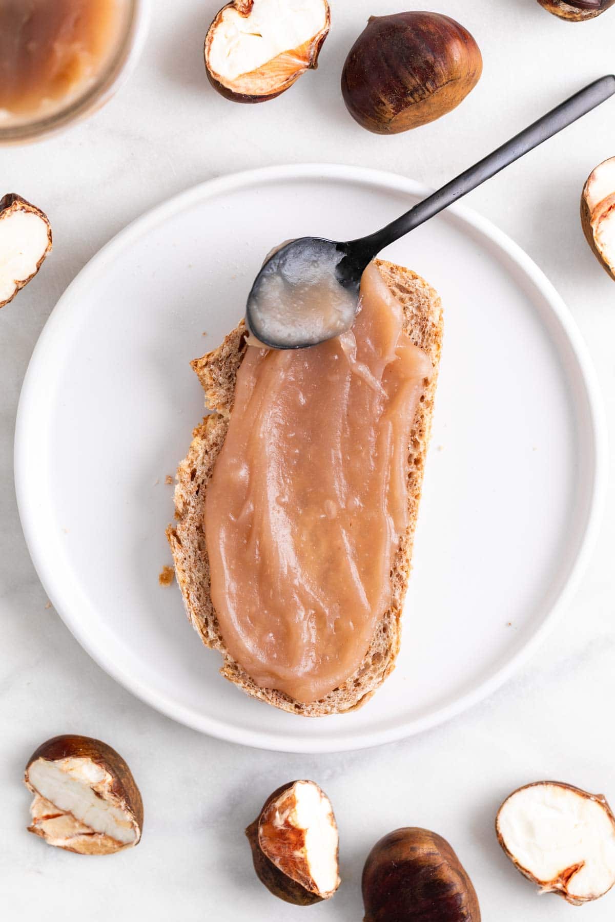 Crema de castañas untada en una rebana de pan sobre un plato.