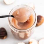 Cuchara con crema de castañas sobre un tarro de crema de castañas casera.