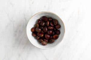 Castañas con un corte hecho en un bol.