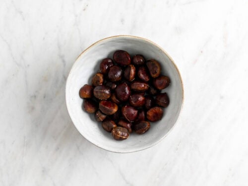 Castañas con un corte hecho en un bol.