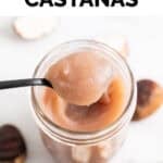 Cucharada de crema de castañas encima de un tarro lleno de crema casera.