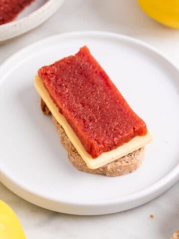 Pan con queso y dulce de membrillo servido en un plato.