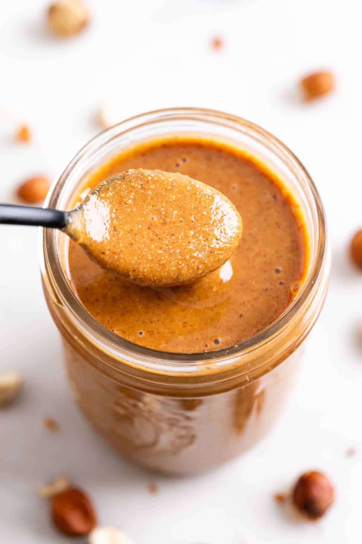 Cuchara levantando crema de avellanas de un tarro.