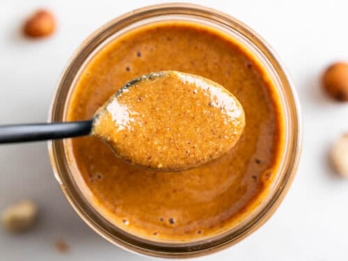 Cuchara con crema de avellanas sobre un tarro.