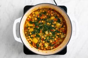 Potaje de garbanzos con verduras cocinado en una olla.