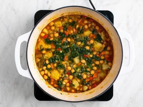 Potaje de garbanzos con verduras cocinado en una olla.