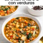 Potaje de garbanzos con verduras servido con pan y cuchara.