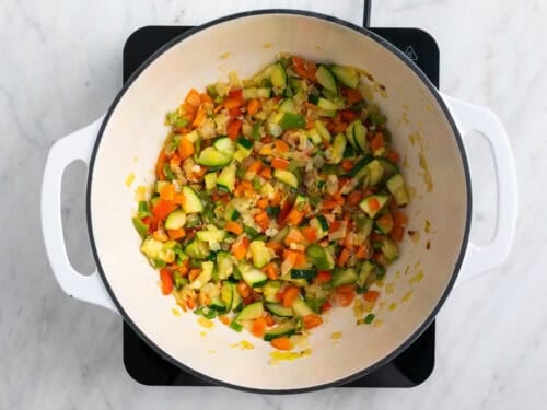 Verduras salteadas en la olla después de echar vino blanco y reducirse.