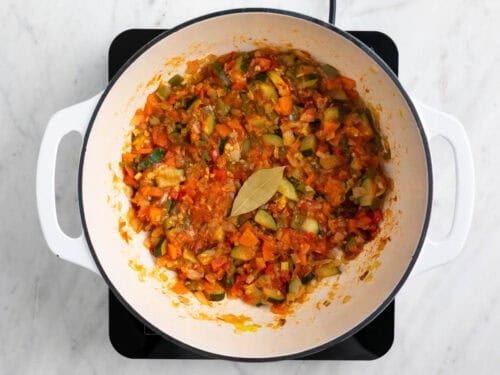Sofrito con pimentón y laurel en una olla.