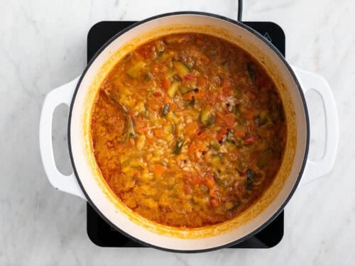 Arroz caldoso con verduras en una olla.