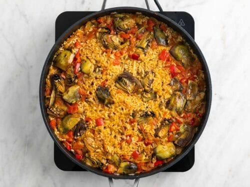 Arroz con alcachofas ya cocinado en la sartén.