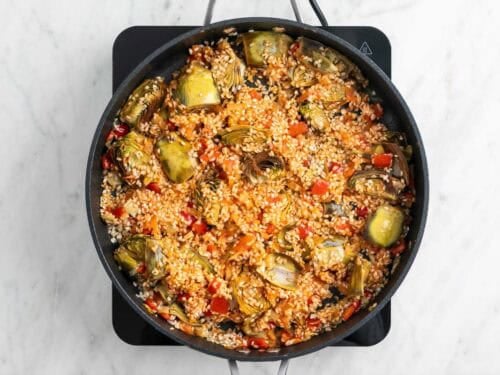 El arroz con el sofrito en una sartén.