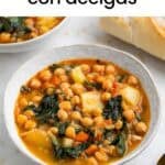 Guiso de garbanzos con acelgas servido con pan y cuchara.