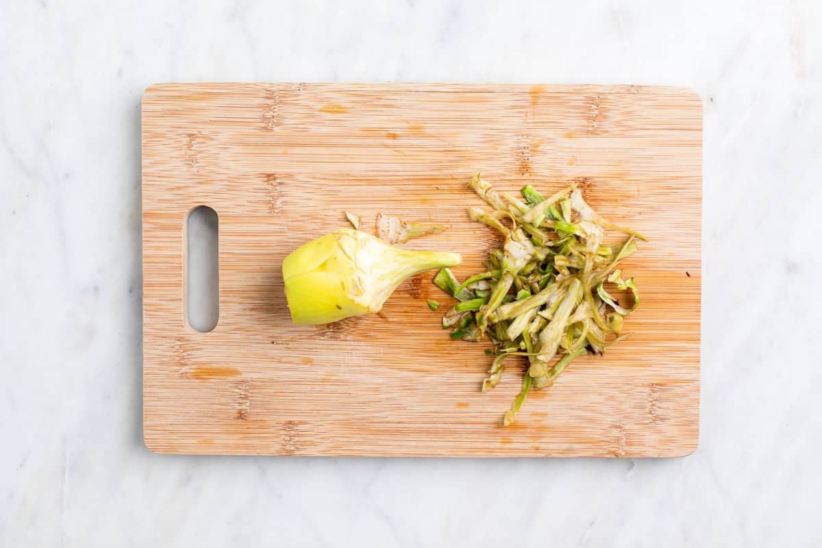 Alcachofa limpia por fuera sobre una tabla.
