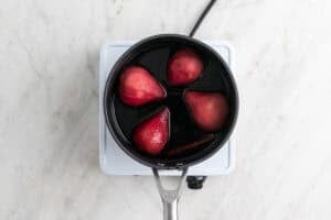 Peras cocinadas en el almíbar en un cazo.