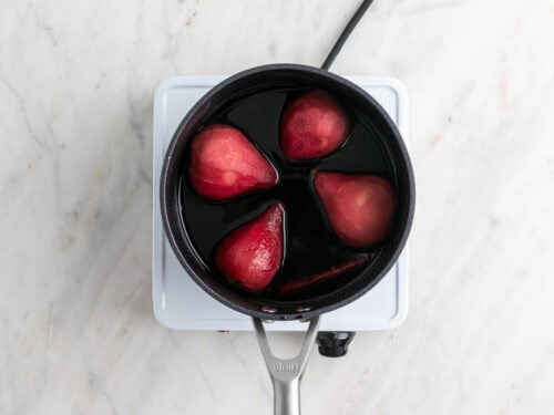 Peras cocinadas en el almíbar en un cazo.