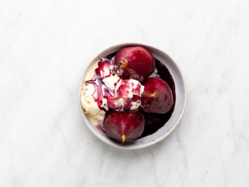 Peras al vino servidas en un plato con helado.