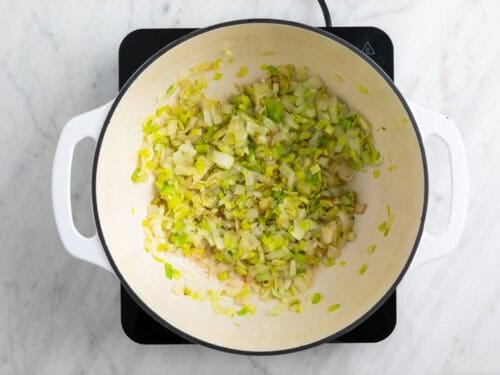 Cebolla y puerro salteados en una olla.