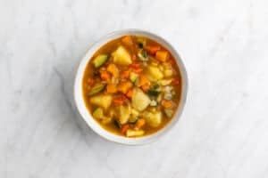 Potaje de verduras servido en un plato.