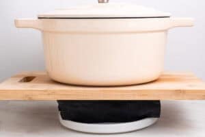 Tofu prensándose envuelvo en un paño de cocina con una olla encima.