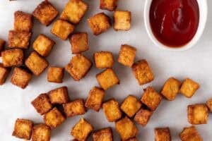 Tofu cocinado en freidora de aire con exterior crujiente y ketchup.