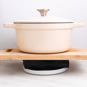 Tofu prensándose envuelvo en un paño de cocina con una olla encima.