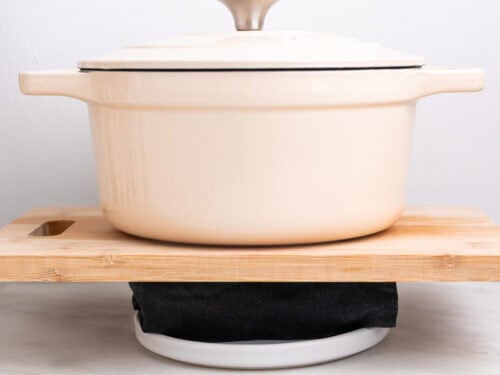 Tofu prensándose envuelvo en un paño de cocina con una olla encima.
