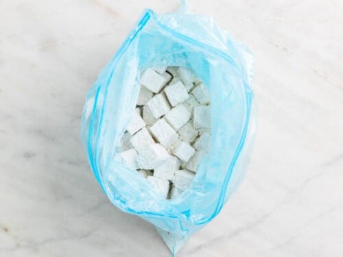 Dados de tofu rebozados en una bolsa de congelación.