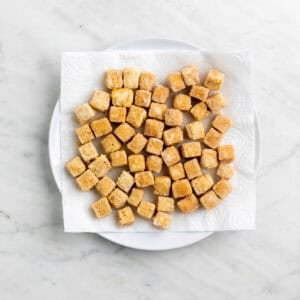 Tofu frito en un plato con papel de cocina.