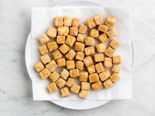 Tofu frito en un plato con papel de cocina.