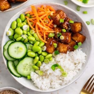 Arroz con tofu crujiente servido en boles, con semillas de sésamo y cebolleta