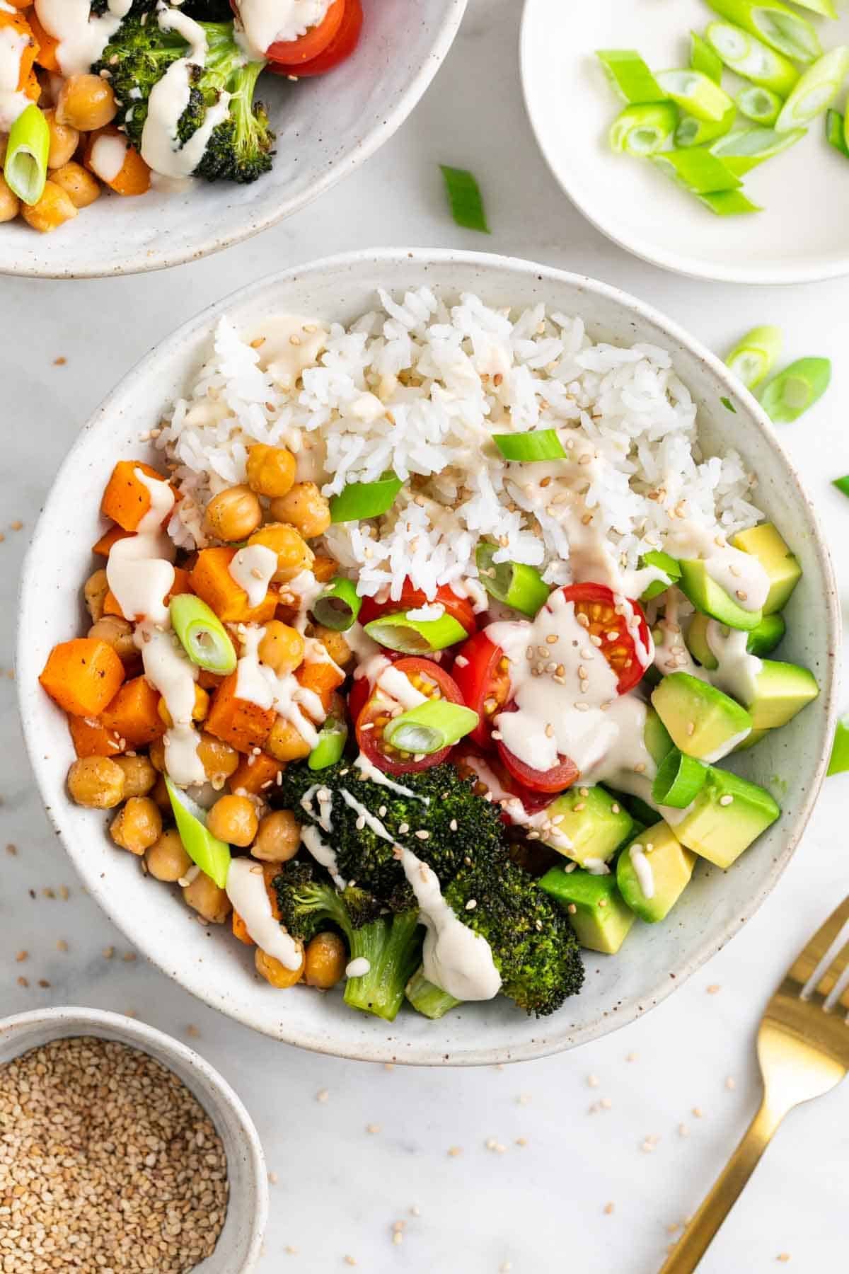 Bol de arroz con verduras asadas, ali&ntilde;o de tahini, s&eacute;samo y cebolleta