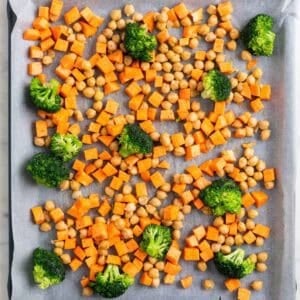 Garbanzos, brócoli y boniato en una bandeja para horno antes de hornear