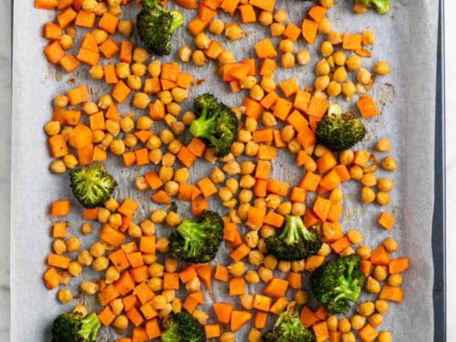 Garbanzos, br&oacute;coli y boniato en una bandeja para horno despu&eacute;s de hornear