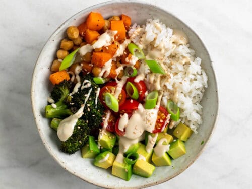 Bol de arroz con verduras y ali&ntilde;o de tahini decorado con s&eacute;samo y cebolleta
