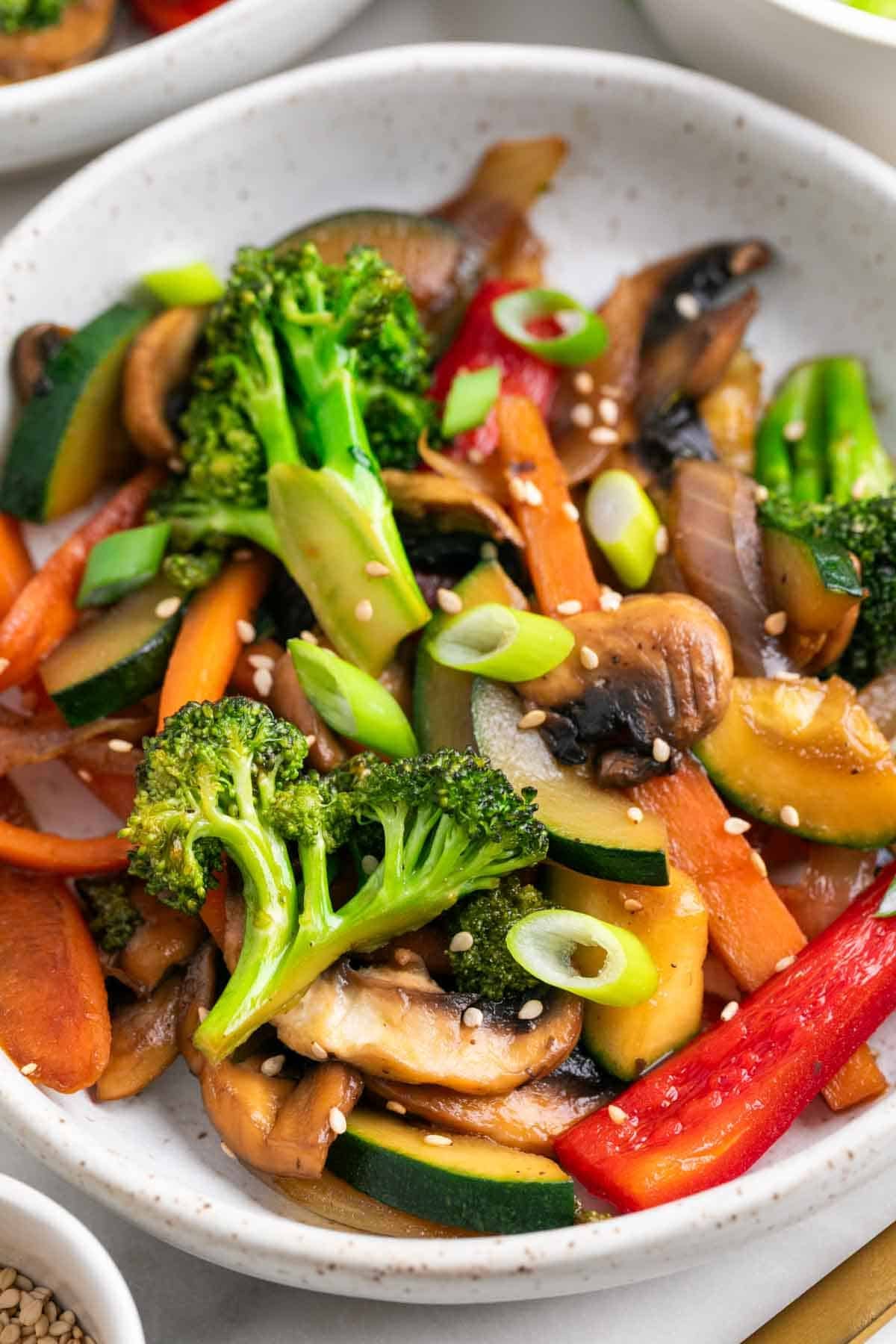 Platos de salteado de verduras sobre la mesa con tenedor.
