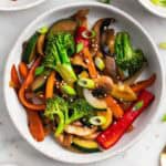 Salteado de verduras con semillas de sésamo y cebolleta por encima.