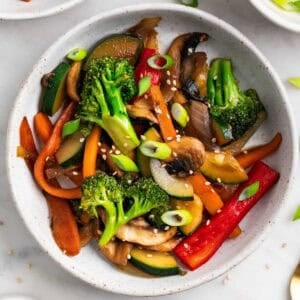 Salteado de verduras con semillas de sésamo y cebolleta por encima.