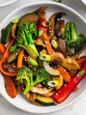 Salteado de verduras con semillas de sésamo y cebolleta por encima.