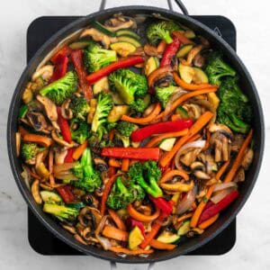 Verduras salteadas en una sartén con salsa de soja y pimienta negra.