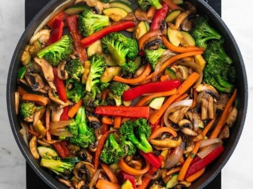 Verduras salteadas en una sartén con salsa de soja y pimienta negra.