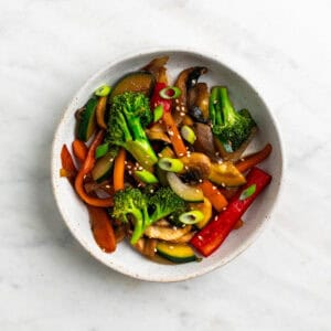Salteado de verduras en un bol con semillas de sésamo.