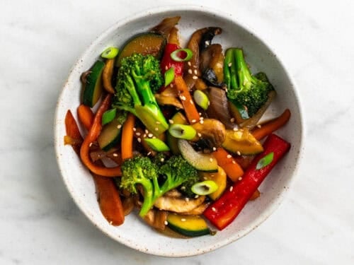 Salteado de verduras en un bol con semillas de sésamo.