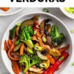 Salteado de verduras servido en dos platos con un tenedor al lado.