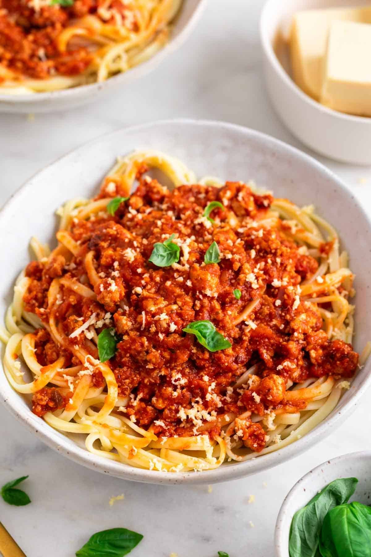 Bol de espaguetis con bolo&ntilde;esa de tofu, albahaca fresca y queso parmesano vegano