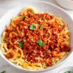 Plato de pasta con boloñesa de tofu y queso parmesano vegano por encima