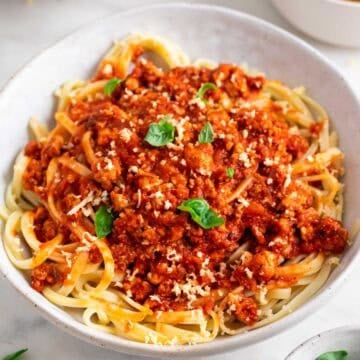 Plato de pasta con boloñesa de tofu y queso parmesano vegano por encima