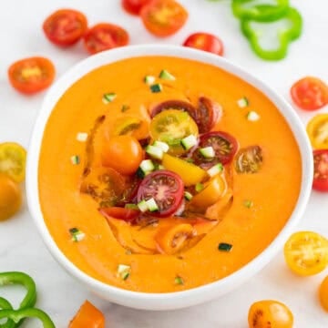 Bol de gazpacho andaluz con un chorrito de aceite de oliva, tomates cherry y pepino troceado