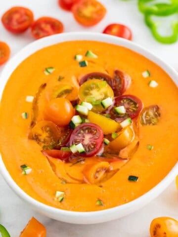 Bol de gazpacho andaluz con un chorrito de aceite de oliva, tomates cherry y pepino troceado